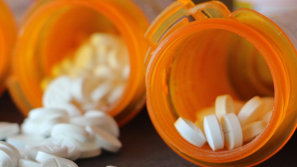 Open pill bottles with tablets spilling out